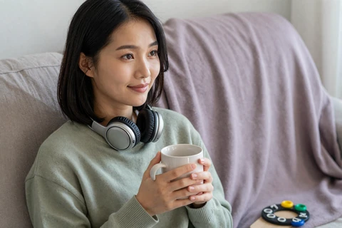 Hana, an autistic adult, decompressing with headphones and a sensory-friendly setup